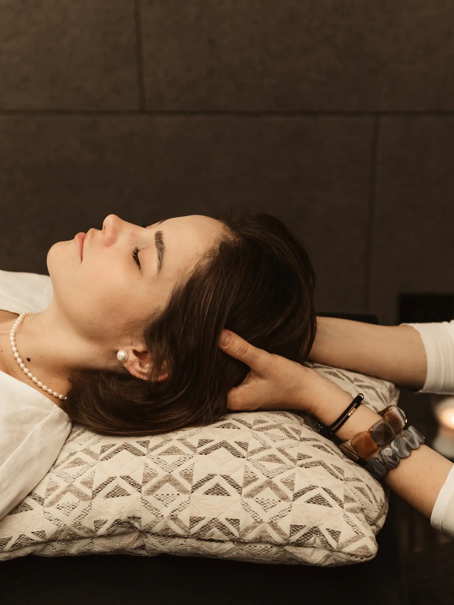 Japanese head spa scalp massage — a practitioner cradling a guest’s head